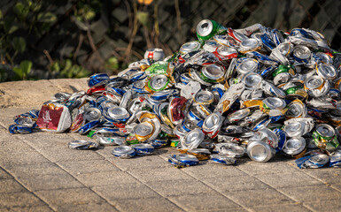 Crushed drink cans on pavement in pile