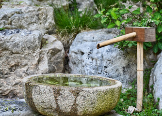 Traditional Water Drip Fountain against Rock Wall