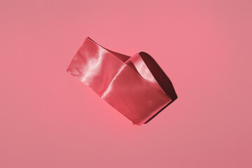 pink satin ribbon on a colored background in hard light
