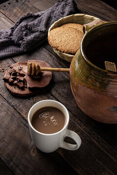 Bebida e ingredientes de Chocolate artesanal sobre mesa de madera antigua con champurradas integrales