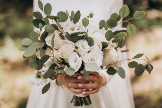 Very beautiful wedding bridal bouquet, made of white roch and austoma, and yellow daisies, green casting of eucalyptus.  Wedding, engagement. Bride and groom. Bride's wedding bouquet.