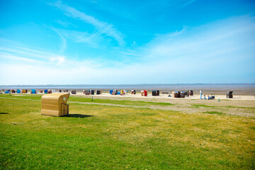 Large beach chair by the sea. Beach on the North Sea with beach chairs. Holiday at the North Sea