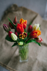 Bouquet of beautiful different varieties of tulips. Beautiful flowers in a vase. Spring bouquet. Bouquet for birthday, Mother's Day, International Women's Day, Valentine's Day. Vertical photo.