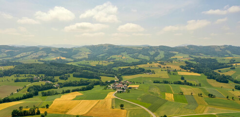 Obraz premium Drone view of a landscape in Austria. Panorama among fields and alpine mountains in Tyrol, Dolomites
