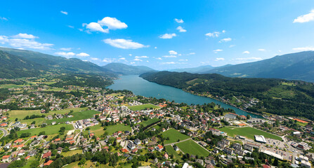 Fototapeta na wymiar Drone view of rainbow over Millstatter see in Austria, in the Dolomites. Aerial video of the lake and houses near it, the calm atmosphere of the Austrian hinterland