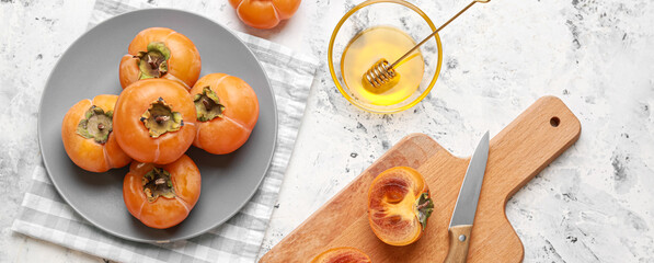 Ripe persimmons with sweet honey on light background, top view