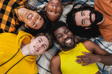 Diverse trendy group of friends having fun together outdoor lying in circle - Diversity and...