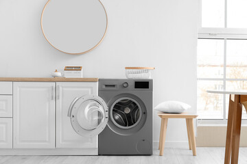 Interior of light kitchen with modern washing machine