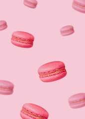 Flying macaroon cakes. MInimal style. Colorful french biscuits on pastel pink background