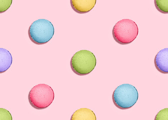 Seamless pattern with french biscuits. Colorful macaroon cakes on pink pastel background