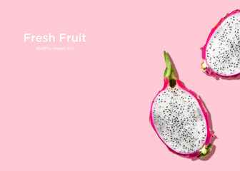 Dragon fruit. Creative layout in top view. Halved fresh ripe pitaya on pink background
