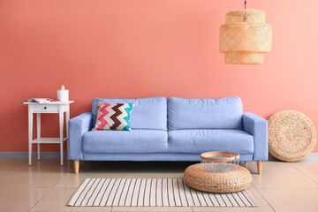 Fototapeta na wymiar Comfortable sofa and table near pink wall in living room