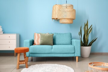 Interior of stylish living room with comfortable sofa near blue wall