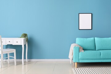 Stylish sofa and table with chair near light blue wall