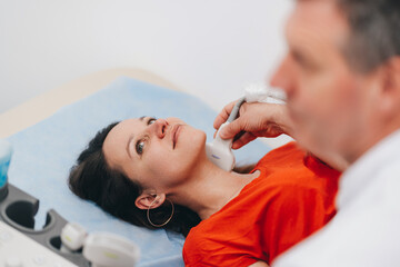 Obraz na płótnie Canvas The woman makes an ultrasound examination of the neck.