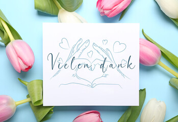 Card with text VIELEN DANK (German for Thanks a lot) and tulip flowers on light blue background