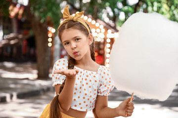 Cute little girl with cotton candy outdoors
