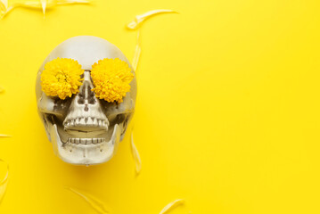 Human skull with flowers and petals on yellow background