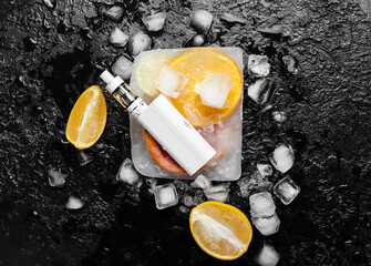 Modern vape mod, orange and ice cubes on black background