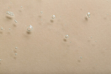 Fototapeta na wymiar Water with bubbles on beige background