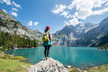 Young woman hiking near Oeschinensee (Oeschinen Lake) in summer, Kandersteg, Switzerland - obrazy, fototapety, plakaty