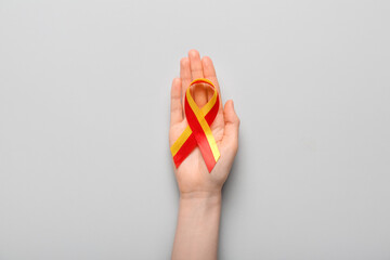 Woman with awareness ribbon on light background. Hepatitis concept