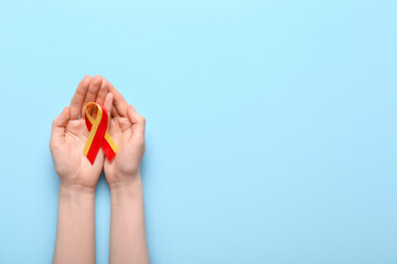 Woman with awareness ribbon on blue background. Hepatitis concept