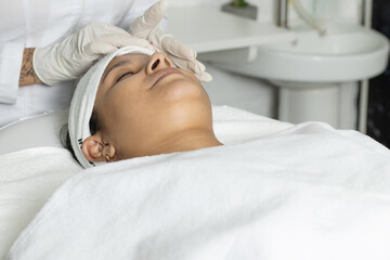 Latina woman with skin treatment, Hispanic doing laser hair removal underarms, dermatology clinic...