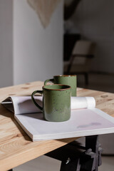 Green mugs on the desktop with a magazine