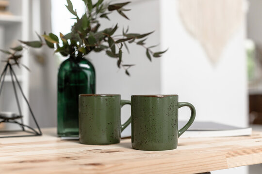 Green mugs on the desktop with a magazine
