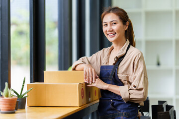 A portrait of Asian woman, e-commerce employ.e freelance with parcel box for deliver to customer....