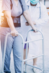 Fototapeta premium young asian physical therapist working with senior woman on walking with a walker