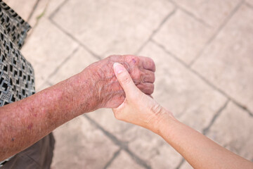 Woman hand holding a senior man's hand. Care for elderly concept.