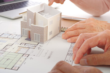 住宅の図面を見ながら検討をするシニア夫婦