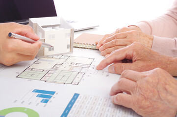 住宅の図面を見ながら検討をするシニア夫婦