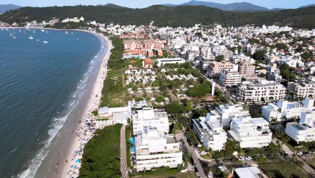 Aerial drone image of beach with building and urbanism in front of the sea, people on the beach nature and constructions live on the beach