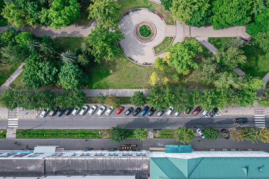 residential area with boulevard and parking lot with cars in sunny summer day. aerial top view.