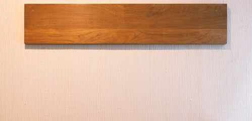 brown wooden board hanging on white wall