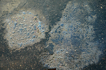 Three oil slicks on the background of an asphalt road.