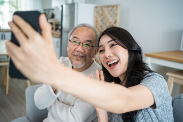 Asian lovely family, young daughter use phone selfie with older father