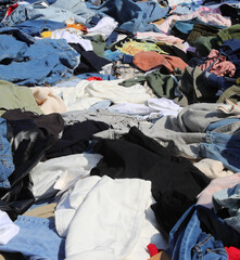 many new and used clothes for sale in the flea market without people