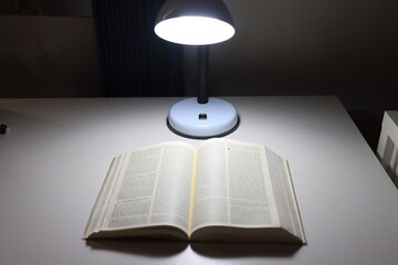 Mesa com a bíblia e luminária