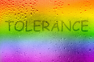 The inscription on the sweaty glass. The word TOLERANCE written on glass with rainbow