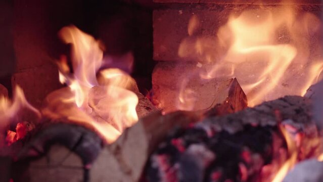 Firewood in oven and fireplace wood. Burning fire, firewood in fireplace. Brick Pizza Oven With Fire. Smoldering charcoal in the oven. Cozy relaxing fireplace background.