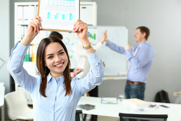 Woman lift document over head, celebrate good deal, beneficial agreement
