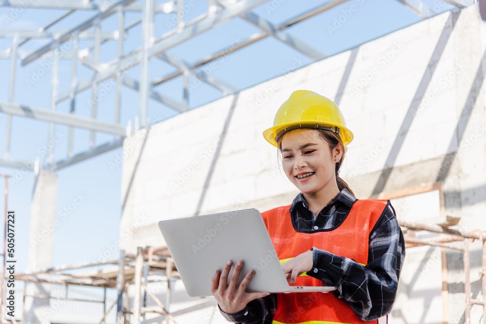 Poster asian engineer architect worker woman holding laptop inspect and oversee infrastructure progress at 