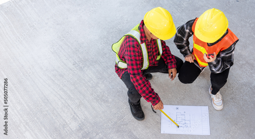 Poster architect and client discuss help create plan with blueprint of the building at construction site fl