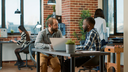 HR recruiter greeting male candidate at job interview application, analyzing cv information and work experience. Diverse team of men discussing about application and recruitment.