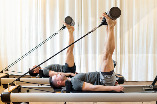 Men working out in a gym doing Pilates hip mobility exercises