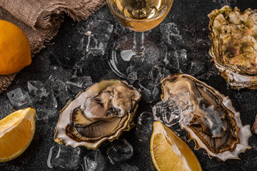 Fresh oysters close-up on ice served with lemon and wine.